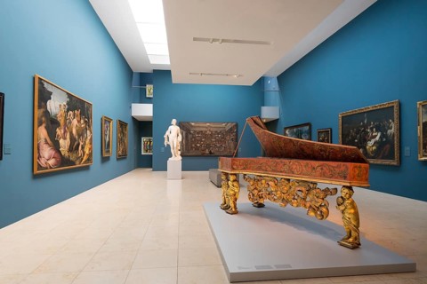 Exhibition space with paintings and harpsichord