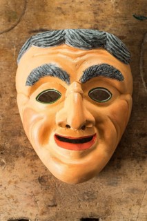 Painted wooden mask on a workbench