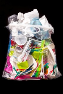 Garbage bag filled with disposable crockery