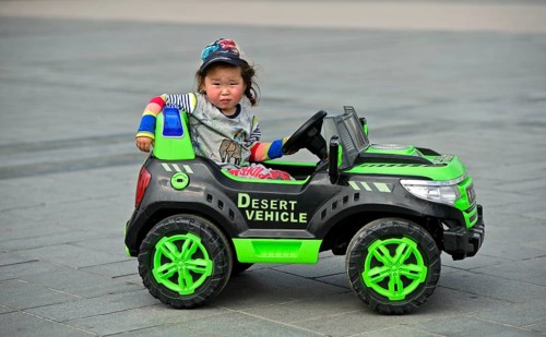 Little girl rides in electric toy car