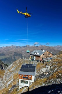 Helicopter Eurocopter AS350 Ecureuil on a supply flight from the Swiss Alpine Club to Lischana Hut
