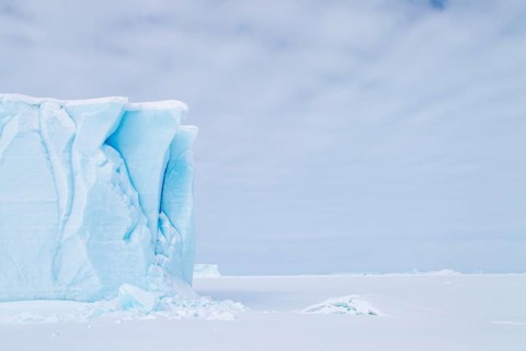 Iceberg seen from frozen fjord