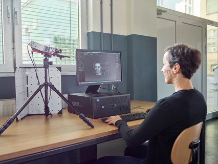30-35 year old woman scans her head with a 3D scanner