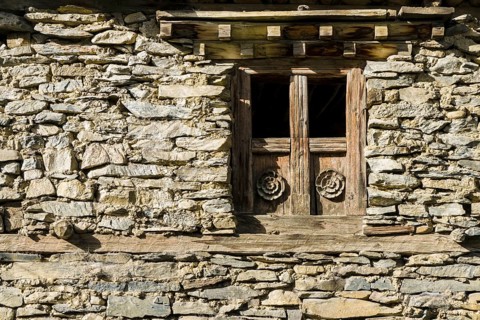 Wooden paneled window of an old stone house