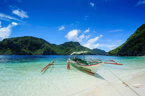 Outrigger boat in the crystal clear water in the Bacuit archipelago