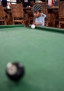 Boy playing billiards