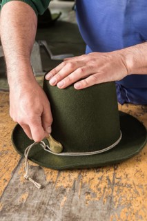 Tightening the shaping cord around a wool felt hat