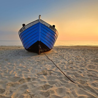 Fishing boat on beach at sunrise
