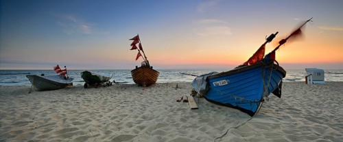 Fishing boats on beach at sunrise