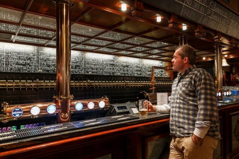 Man holding a glass of beer at Olhallen