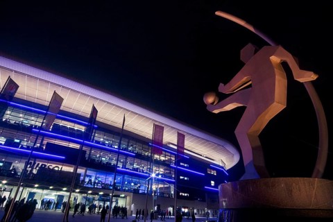 Sculpture of a soccer player in front of Wirsol Rhein-Neckar-Arena illuminated at night