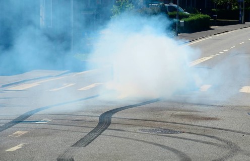 Car burning tire on a street