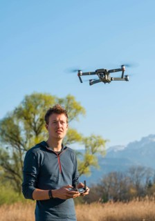 Young man controlling flying quadrocopter