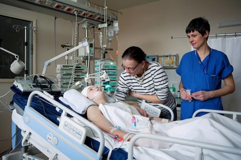 Child with mother and intensive care nurse at the bedside