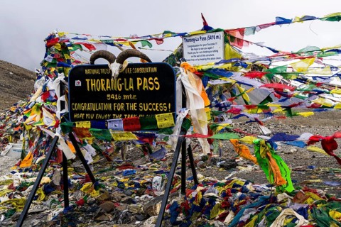 Tibetan prayer flags at sign Thorong-La Pass