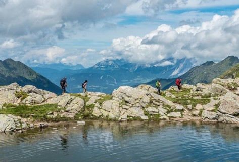 Hikers on trail by mountain lake