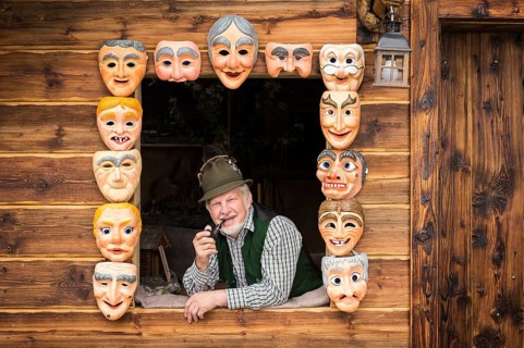 Wooden mask carver in a window