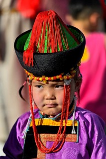 Little girl in traditional Deel clothes and hat with cone-shaped lace