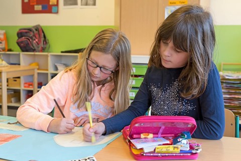Girls painting in elementary school