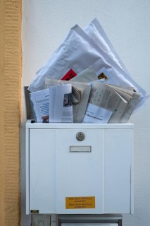Overfilled mailbox with letters and newspapers