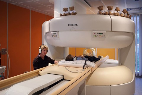 Mother with child at MRI scan on the foot