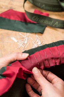 Hands folding and fastening silk ribbon using pins