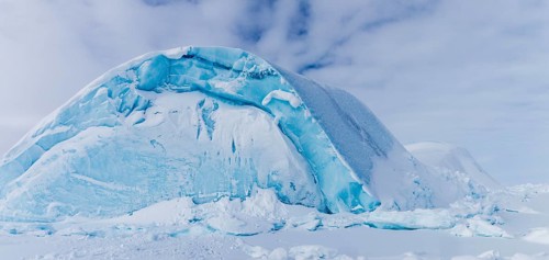 Iceberg seen from frozen fjord