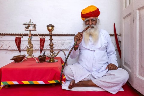 Elderly Indian man with turban smoke hookah