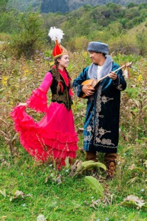 Kazakh man singing and playing the dombra for a woman