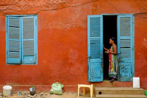 Woman in the door of a colonial building on the Isle de Goree