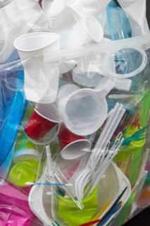 Garbage bag filled with disposable crockery