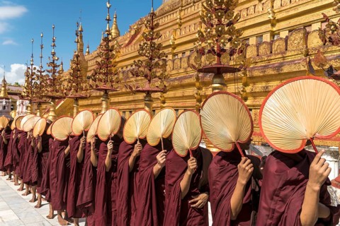 Monks with fans waiting for donations