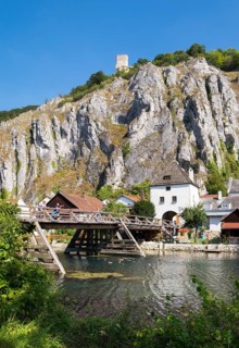 Old wooden bridge over side arm of the Altmuhl River with Randeck Castle