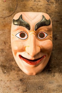 Painted wooden mask on a workbench