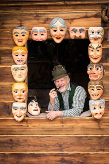 Wooden mask carver in a window