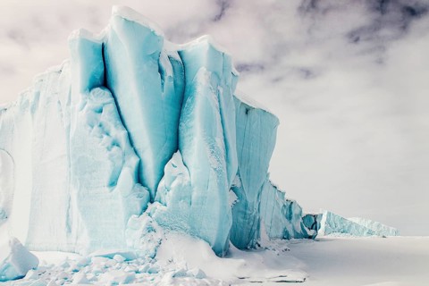 Iceberg seen from frozen fjord