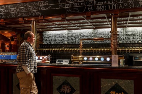 Man holding a glass of beer at Olhallen