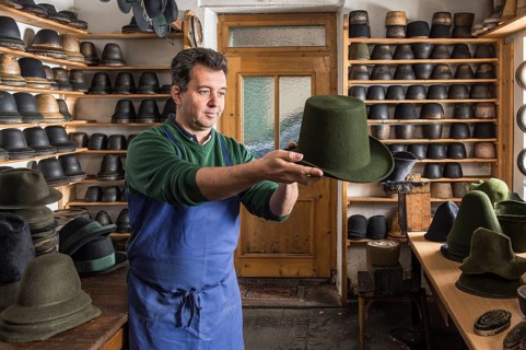 Hatter examining finished wool felt hat