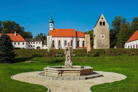 Monastery church with Roman tower and fountain with fountain figure of abbot Walto or Balto