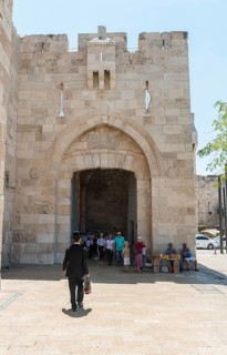 Man with traditional Jewish clothes in front of the city wall