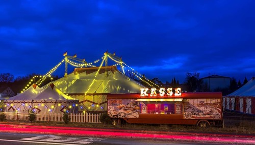 Travelling circus with counter illuminated at dusk