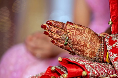 Traditional bridal jewelry and henna decoration on the hands of the bride during a religious ceremony at a Hindu wedding
