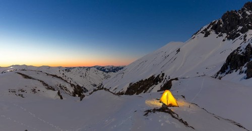 Illuminated tent in the snow on the Madelejoch