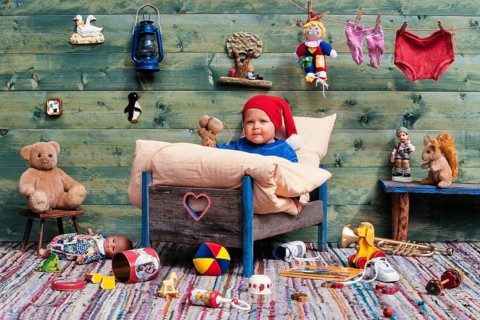 Three-year-old girl in bed with toys