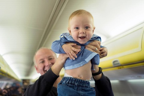 Father standing with his six months old baby boy in the airplane