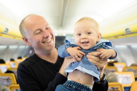 Father standing with his six months old baby boy in the airplane