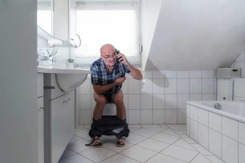 Senior man sitting on the toilet