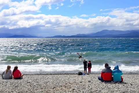 People sitting on the beach of Lago Nahuel Huapi