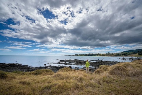Middle-aged woman standing on the coast of East Cape