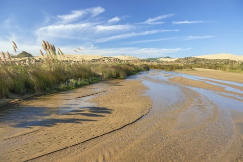 Access through a streambed to the beach Ninety Mile Beach between sand dunes
